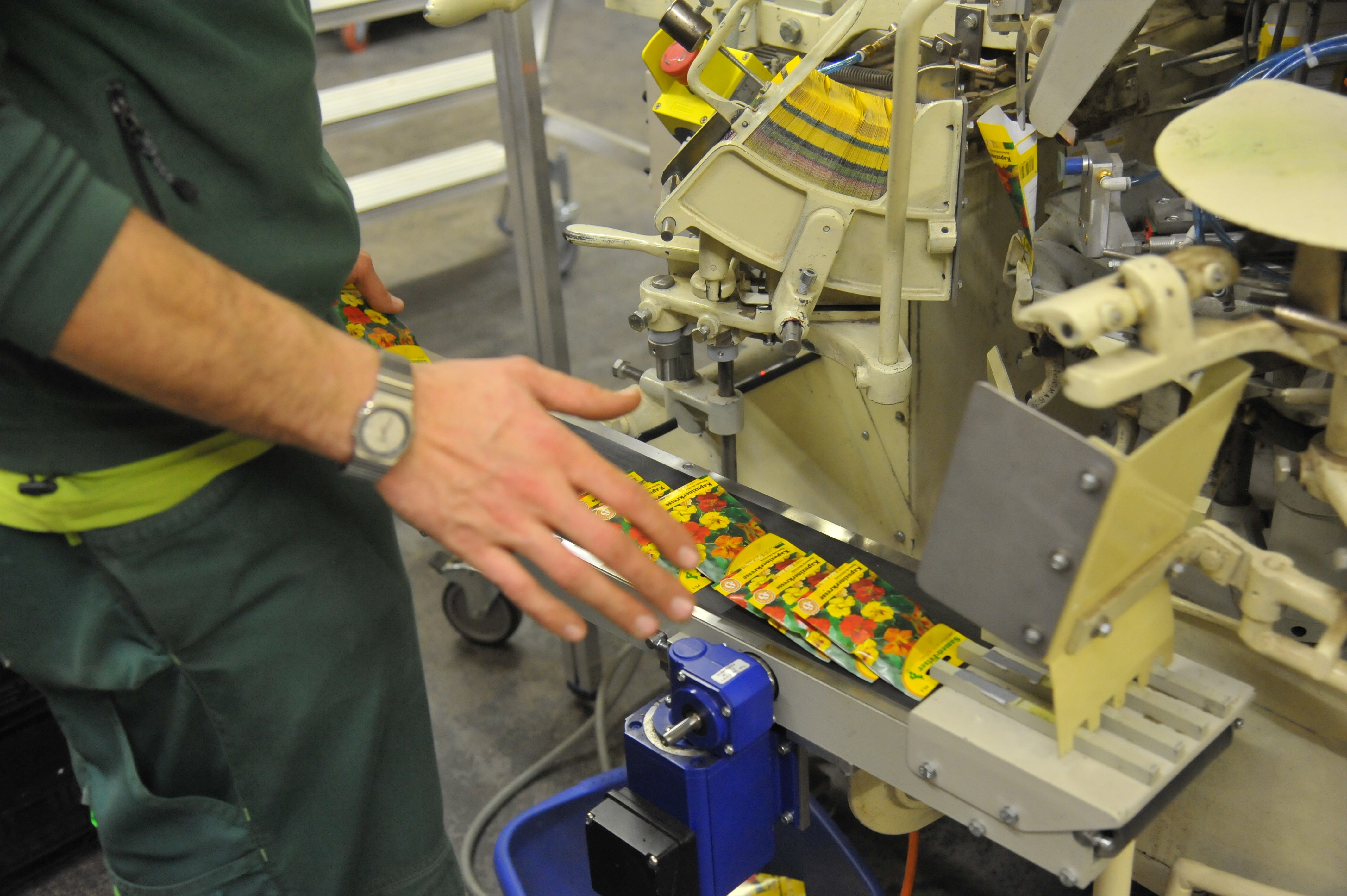 Arbeiter an einer Verpackungsmaschine, die Pflanzenetiketten in der Produktion verarbeitet